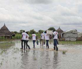 MSF teams in South Sudan wade through a flooded village to deliver medicine. 