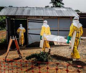 MSF staff members carry a deceased Ebola patient to the morgue in Kailahun, Sierra Leone. 