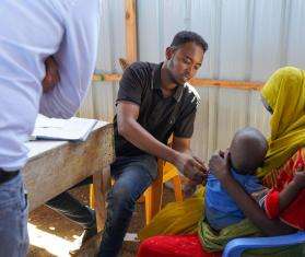 Health care worker measuring arm circumference of a child in Baidoa, Somalia