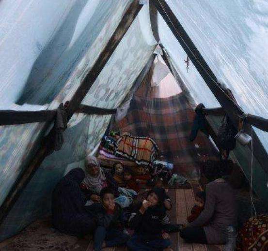 Displaced Palestinians inside a tent in Rafah, Gaza.