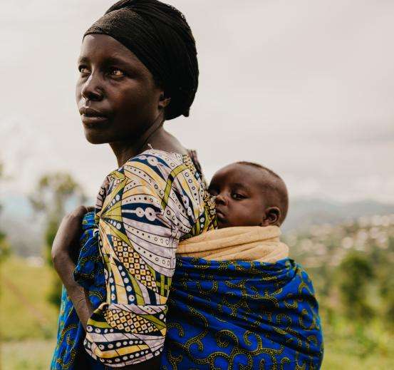 A woman carries her child on her back in Bugeri camp, Minova health zone, South Kivu province, eastern Democratic of Congo.